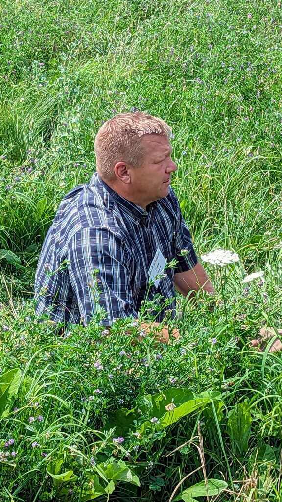 A man sitting in a forage field.